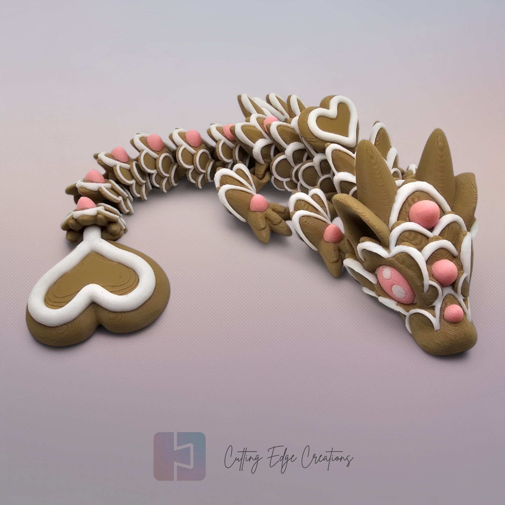 3D printed cookie style articulated dragon with pink and white icing details