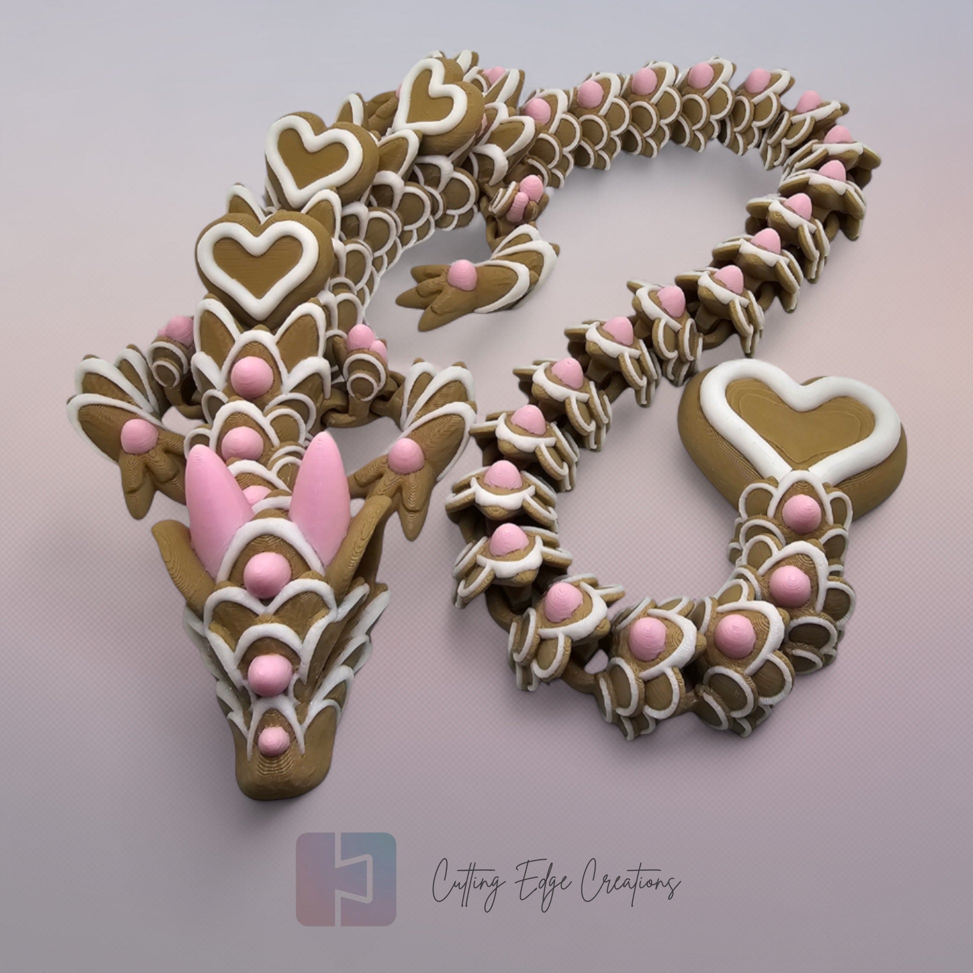 3D printed cookie style articulated dragon with pink and white icing details