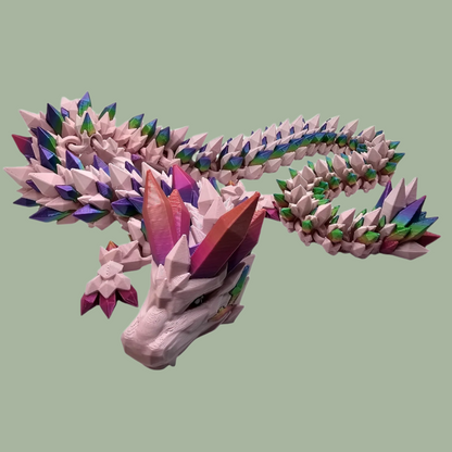 3D printed crystal style dragon in pink with rainbow detail along the body