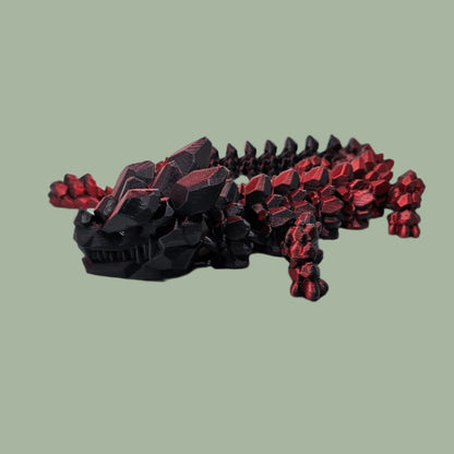 3D printed articulated dragon with rock detail, in a red/black colour