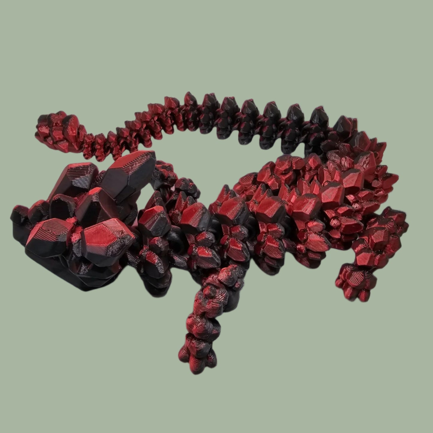 3D printed articulated dragon with rock detail, in a red/black colour
