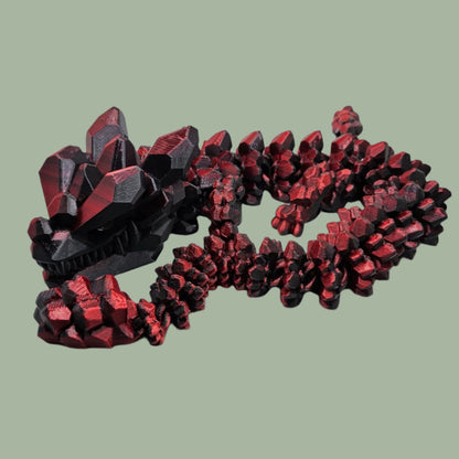 3D printed articulated dragon with rock detail, in a red/black colour
