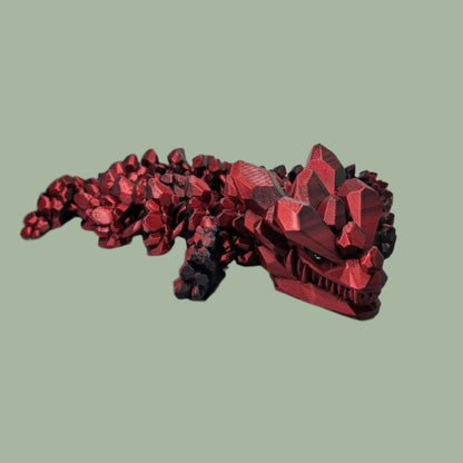 3D printed articulated dragon with rock detail, in a red/black colour