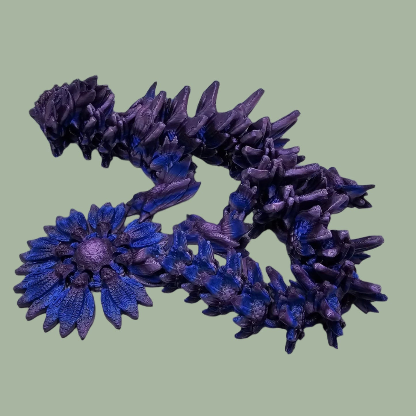 3D printed articulated dragon with sunflower detail, in a purple/blue/pink  colour