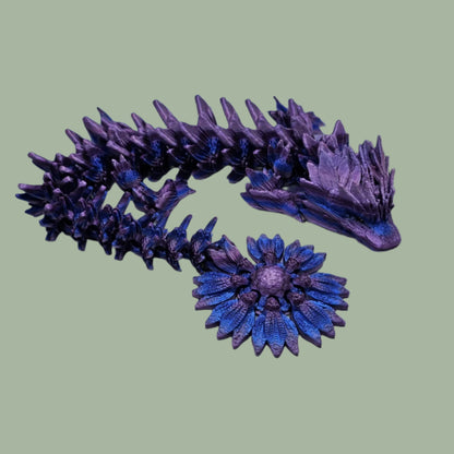 3D printed articulated dragon with sunflower detail, in a purple/blue/pink  colour