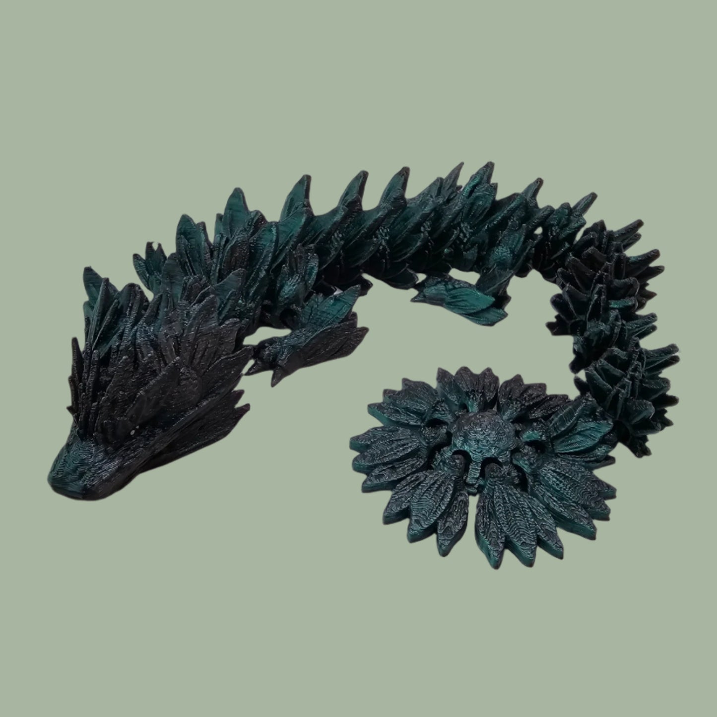 3D printed articulated dragon with sunflower detail, in a black/green colour