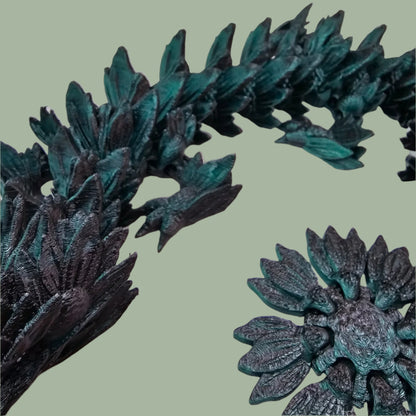 3D printed articulated dragon with sunflower detail, in a black/green colour