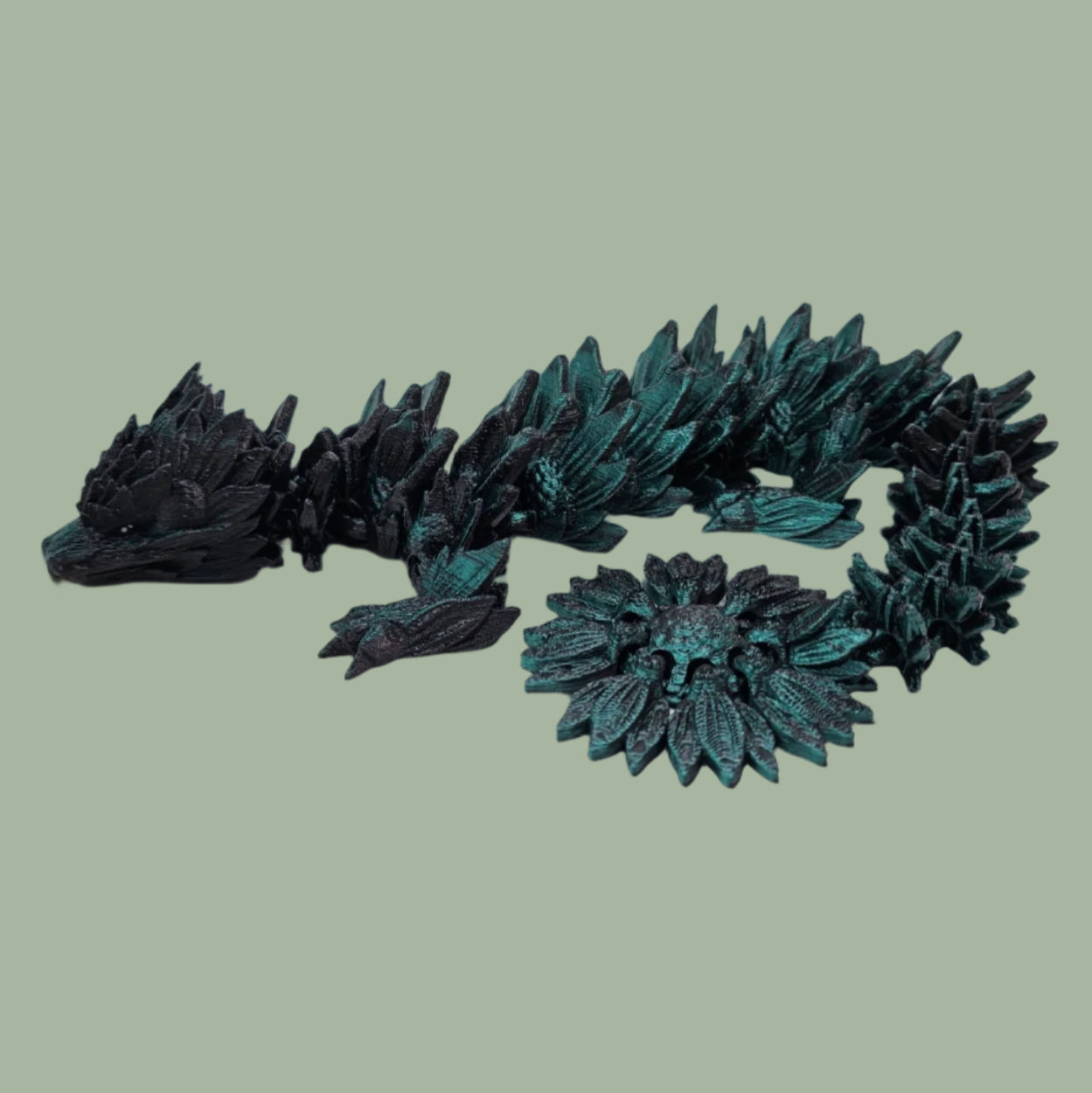 3D printed articulated dragon with sunflower detail, in a black/green colour