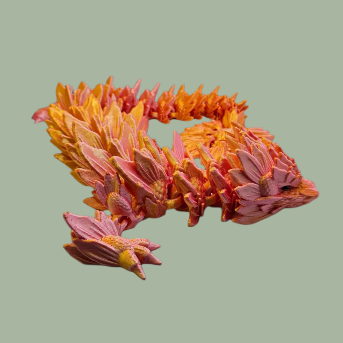 3D printed articulated dragon with sunflower detail, in a orange/pink colour