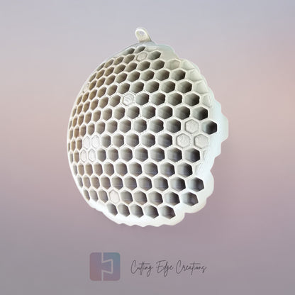 A 3D printed fake wasp nest with a honeycomb pattern, mounted under a wooden shed roof to deter real wasps.