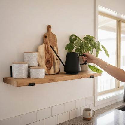 Cutting Edge Creations rustic reclaimed timber scaffold board shelf with black brackets, styled with wooden cutting boards, white jars, and a plant.