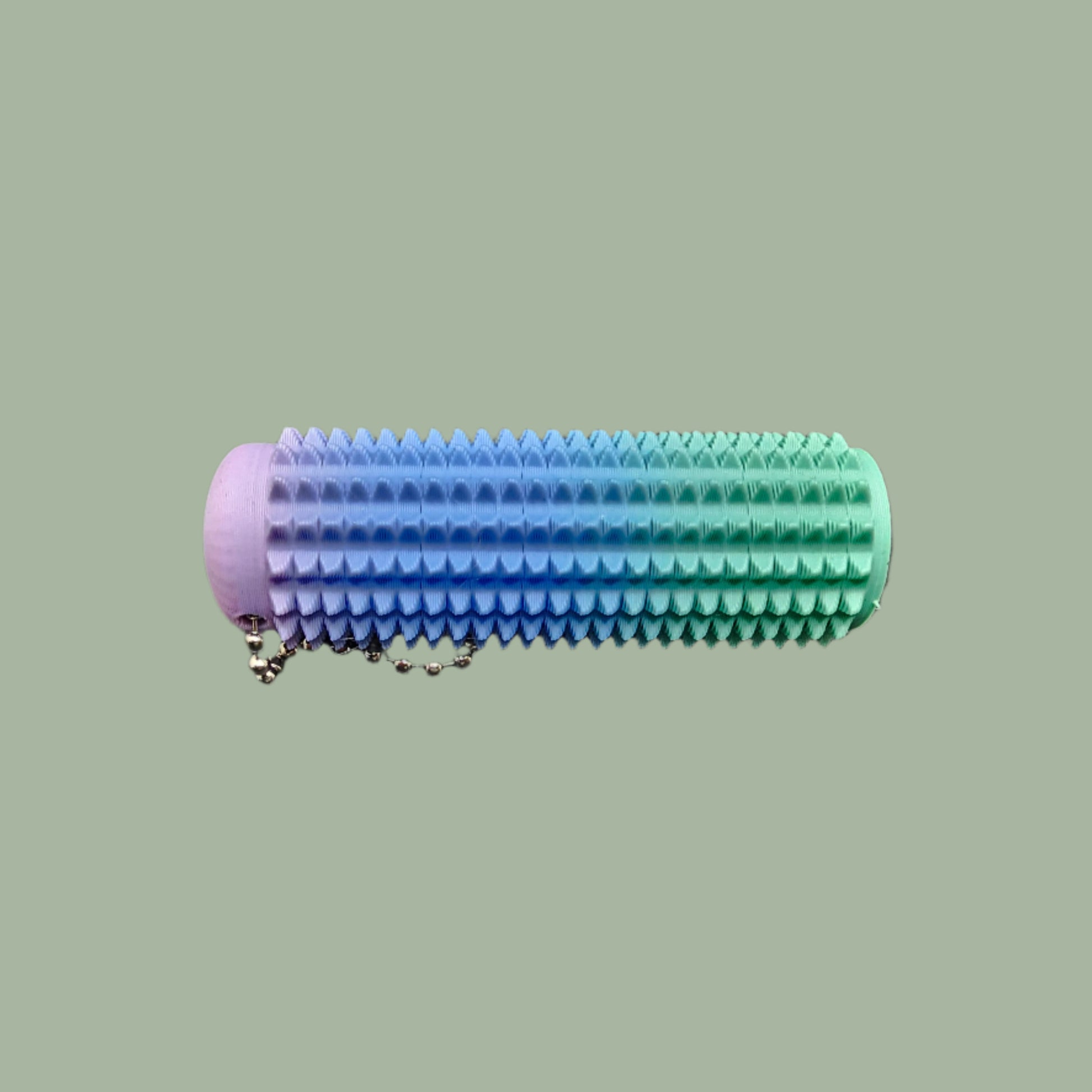 Mini Ouchie Pain Stim – a 7cm long, 3D-printed sensory tool with textured spikes for tactile stimulation, displayed against a neutral background. Includes a keychain for easy portability