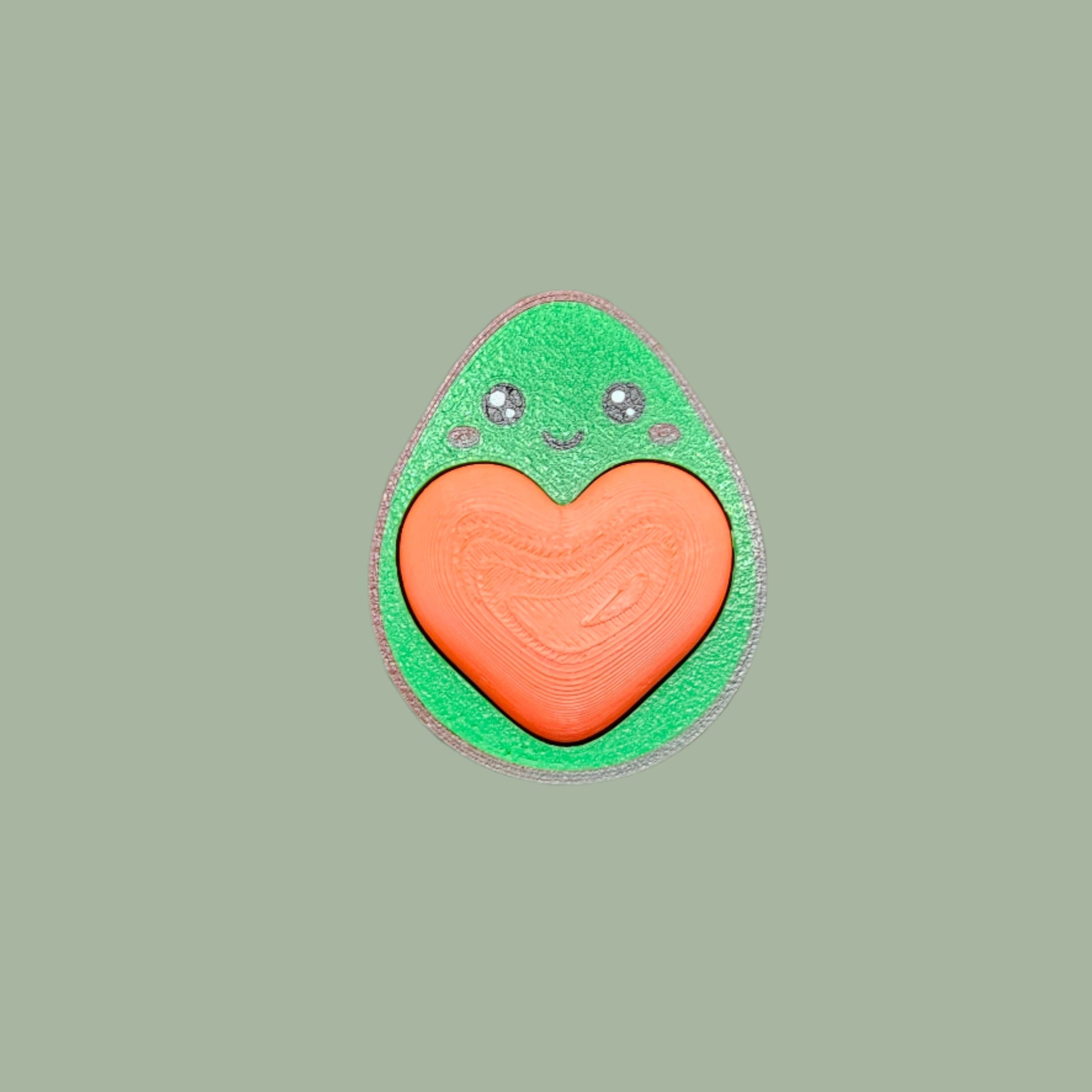 Cute 3D-printed avocado fidget clicker keychain with a heart-shaped clickable stone. Small stress relief toy, 5.5cm tall, made in the UK. Perfect for fidgeting, anxiety relief, and as a fun keyring accessory