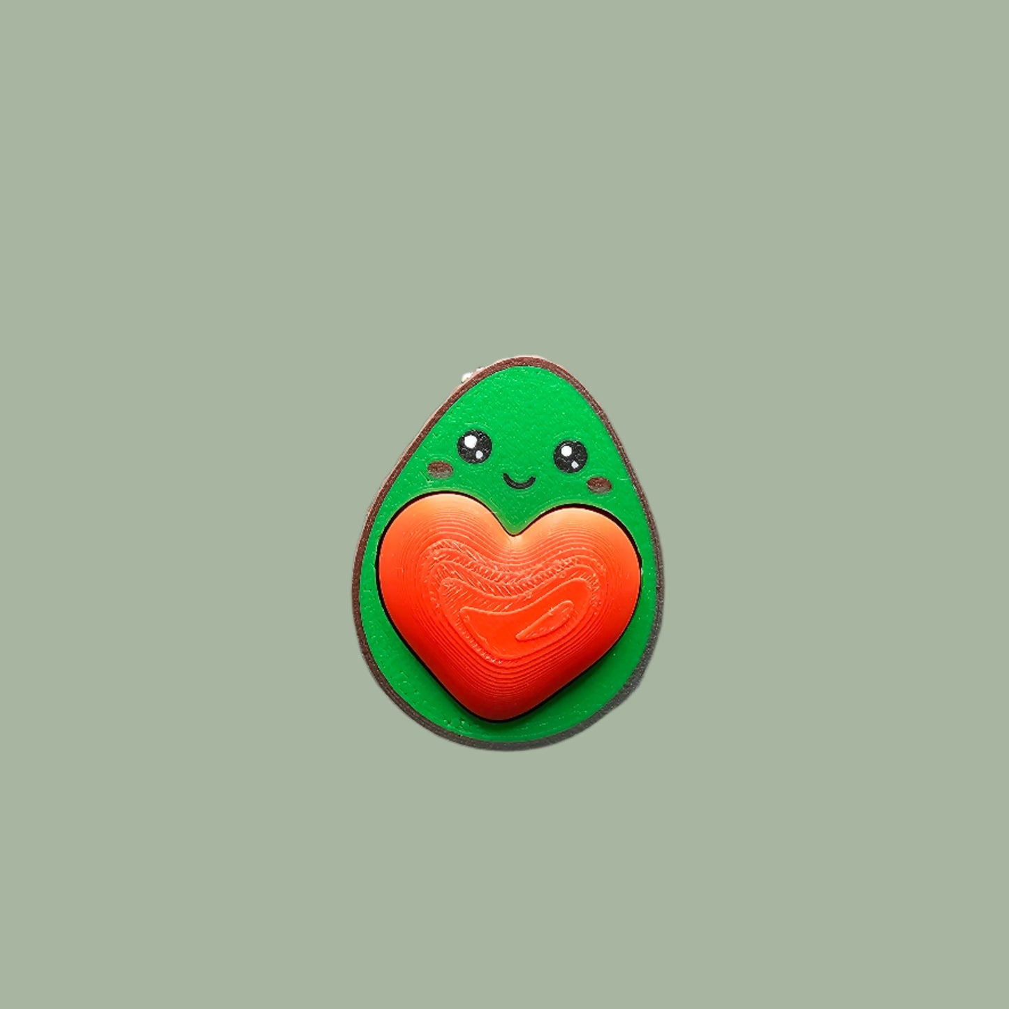 Cute 3D-printed avocado fidget clicker keychain with a heart-shaped clickable stone. Small stress relief toy, 5.5cm tall, made in the UK. Perfect for fidgeting, anxiety relief, and as a fun keyring accessory