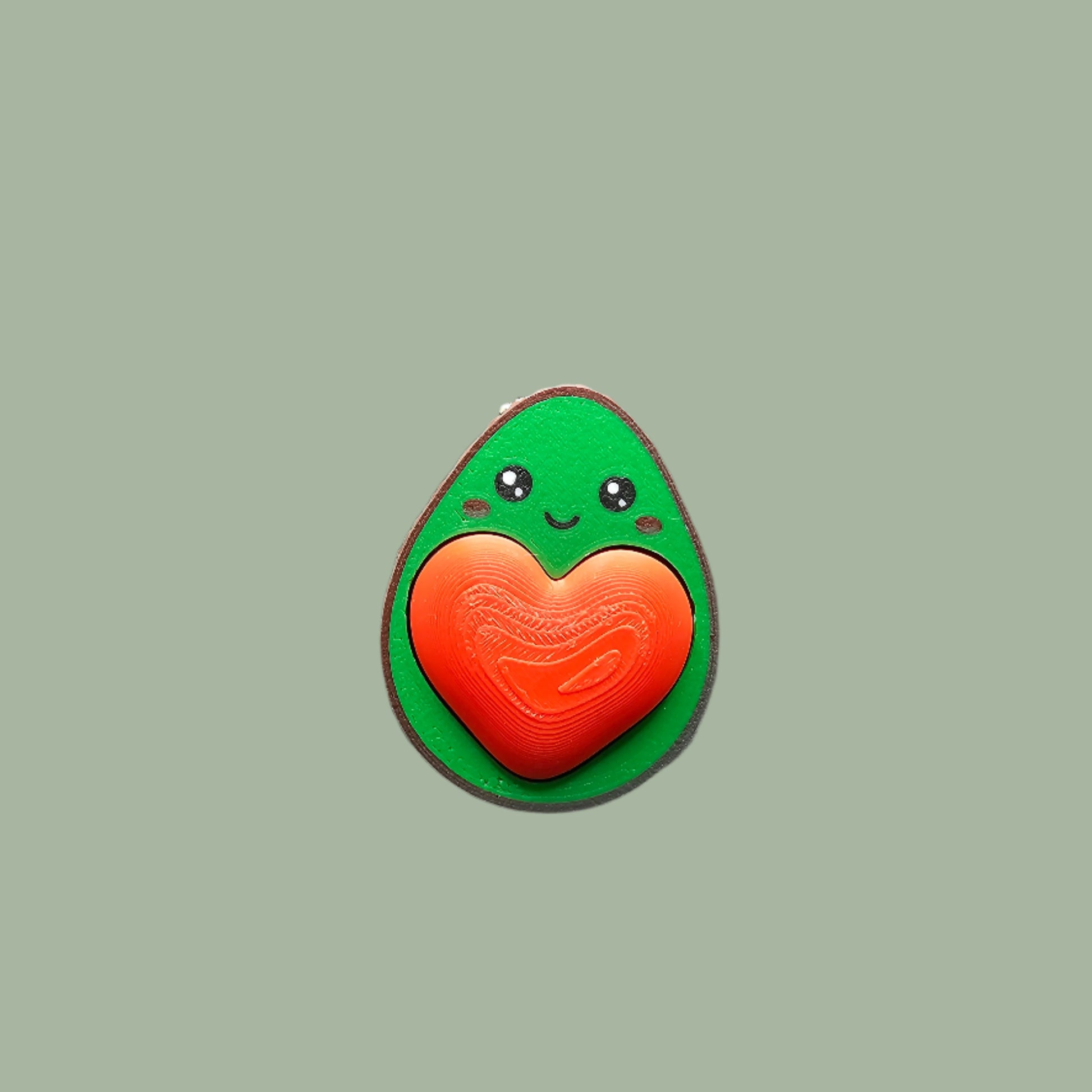 Cute 3D-printed avocado fidget clicker keychain with a heart-shaped clickable stone. Small stress relief toy, 5.5cm tall, made in the UK. Perfect for fidgeting, anxiety relief, and as a fun keyring accessory