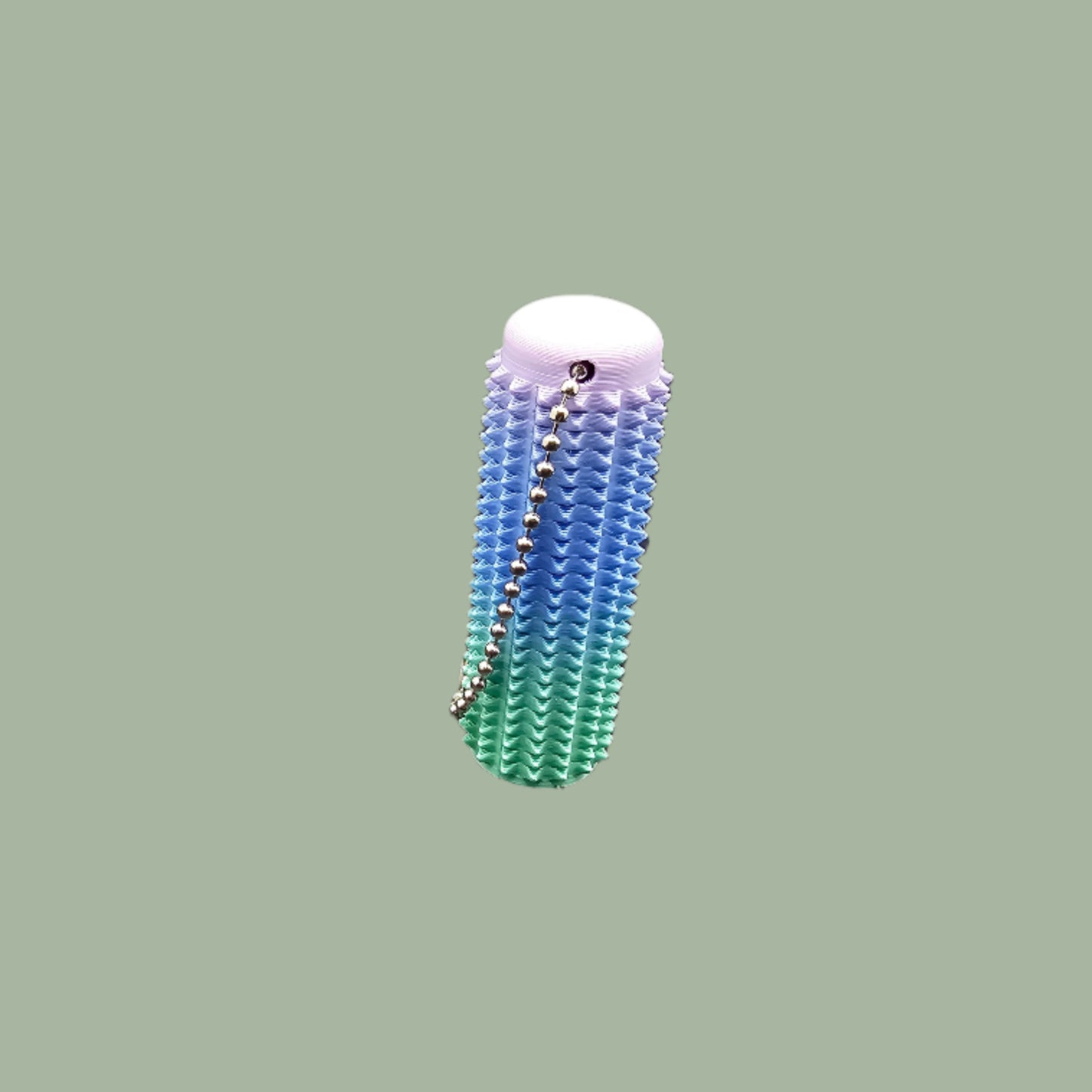 Mini Ouchie Pain Stim – a 7cm long, 3D-printed sensory tool with textured spikes for tactile stimulation, displayed against a neutral background. Includes a keychain for easy portability